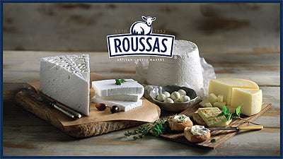 A block of Authentic Traditional Greek Roussas Feta Cheese on a wooden cutting board.