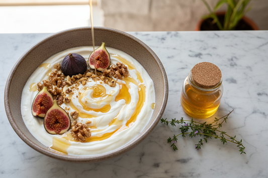 Bowl of authentic Greek yogurt with golden thyme honey, walnuts and fresh figs on marble surface