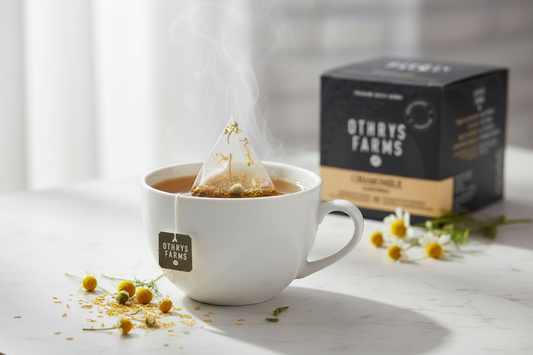 Othrys Farms Chamomile pyramid tea bag steeping in ceramic cup on white marble